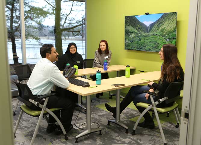 Students and faculty members sitting in a conference room at Oakton College.